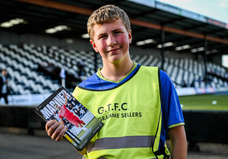 GTFC Programme Seller holding copies of The Mariner